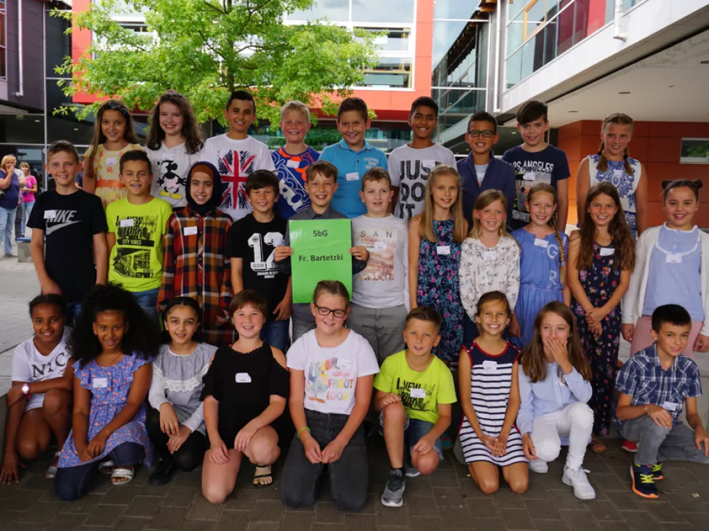 Klassenfoto einer neuen fünften Klasse im Schulhof.